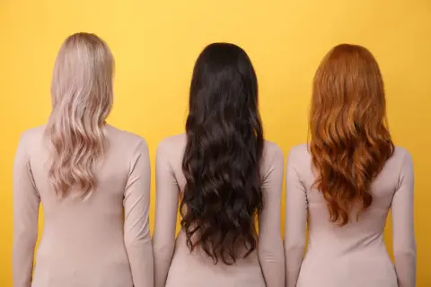Trzy kobiety z różnymi kolorami włosów: blond, brązowe i rude. Zastanawiasz się, jak szybko rosną włosy?