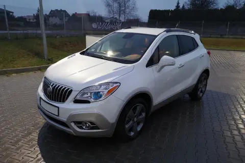 Biały Buick Encore stoi na mokrej, brukowanej nawierzchni.