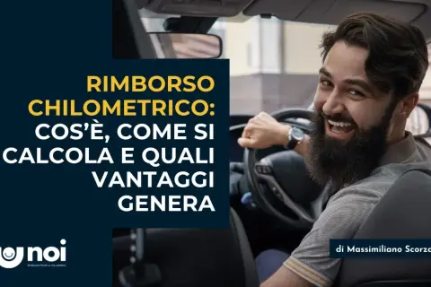 Uomo sorridente al volante discute il rimborso spese chilometrico: cos'è, come si calcola e i vantaggi.