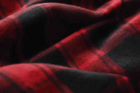 Rotes und schwarzes Karomuster auf weichem Stoff. Das ist typisch für Flanell, das sich warm und gemütlich anfühlt.