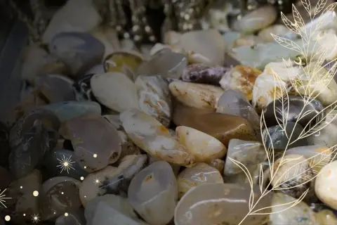 Mnóstwo gładkich, błyszczących kamieni, jakby znalezionych na polskiej plaży. Wśród nich można dostrzec cenne kamienie w Polsce, mieniące się w świetle.