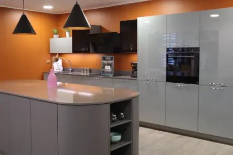 Cuisine moderne avec îlot central gris et armoires bleues claires, parfaite pour rénover une cuisine avec style.