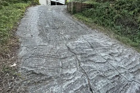 Stromy podjazd z popękanego betonu, porośnięty trawą. Zastanawiasz się, czym wyłożyć stromy podjazd, by był bezpieczniejszy i estetyczniejszy?
