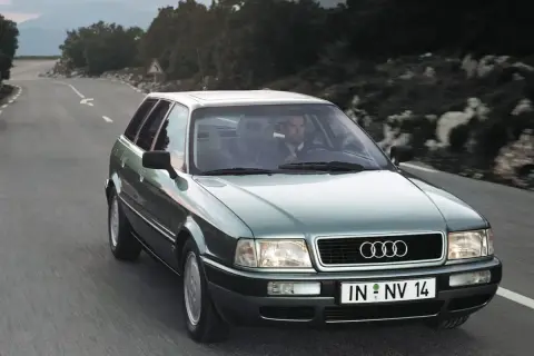 Zielony Audi 1.9 TDI na krętej drodze, kierowca w garniturze.