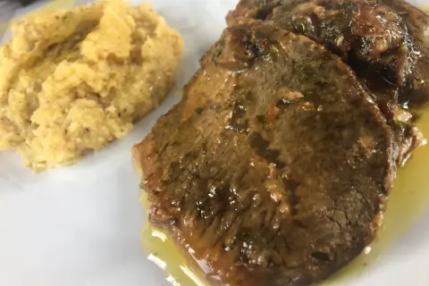 Fette di carne in umido con polenta, un classico della ricetta bresciana.
