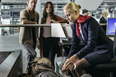 Para sprawdzić, ile bagaż podręczny Ryanair zmieści się w tej ramce, para czeka na odprawę.