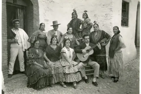 Grupo de gitanos en Granada, con un hombre tocando la guitarra. Captura la esencia del significado del flamenco.