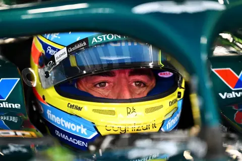 Ojos concentrados de Fernando Alonso con casco Aston Martin, listo para la carrera.