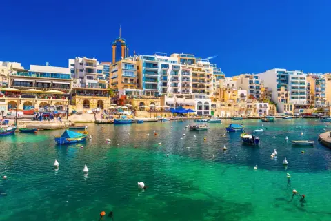 Malta, St Julian's: malowniczy port z turkusową wodą, łodziami i nowoczesnymi budynkami.