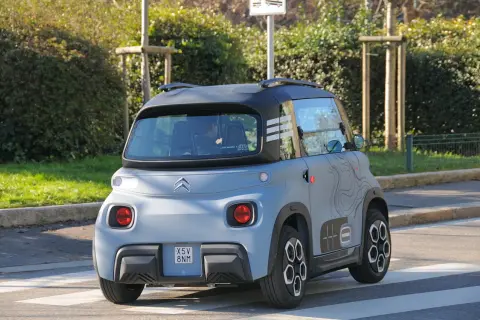 Citroën Ami in prova su strada, vista posteriore. Un veicolo elettrico compatto e originale, ideale per la mobilità urbana.