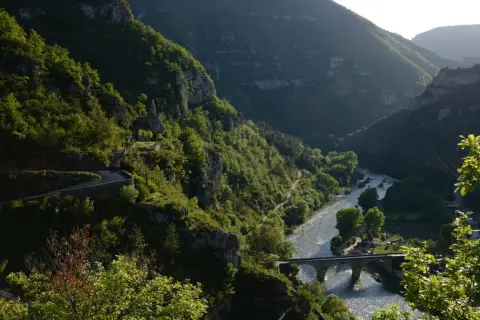 La famille Bournazel profite d'une vue spectaculaire sur une vallée verdoyante, une rivière scintillante et un pont de pierre.