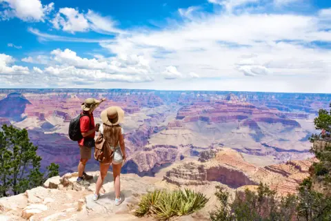 Paar bestaunt Grand Canyon. Tolle USA Reisetipps für unvergessliche Ausblicke und Abenteuer.