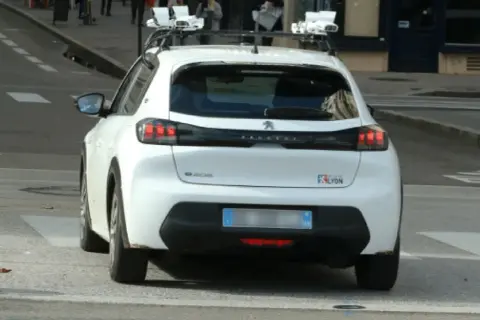 Voiture radar privé, équipée de capteurs sur le toit, en fonctionnement dans la ville de Lyon.