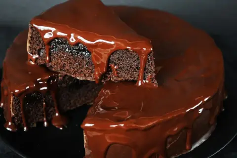 Saftiger Schokokuchen mit glänzender Schokoladenglasur, der wie von Zauberhand im Thermomix entstanden ist.