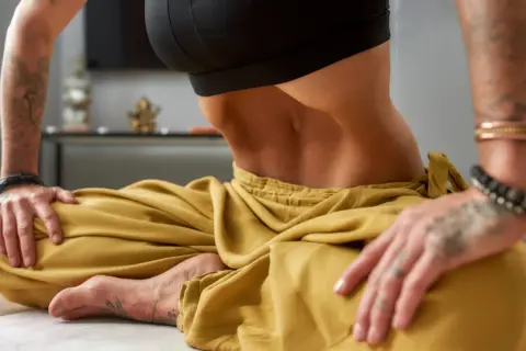 Résultats impressionnants de stomach vacuum. Une personne en tailleur, ventre rentré, montrant la puissance de cette technique.