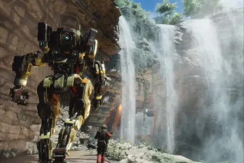 Potężny mech z gry Titanfall 3 stoi obok wodospadu, a pilot w skafandrze bojowym wpatruje się w niego.