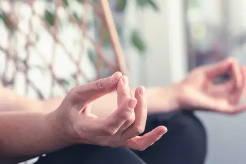 Mains en mudra, pratiquant des exercices de yoga des mains pour la relaxation et la concentration.