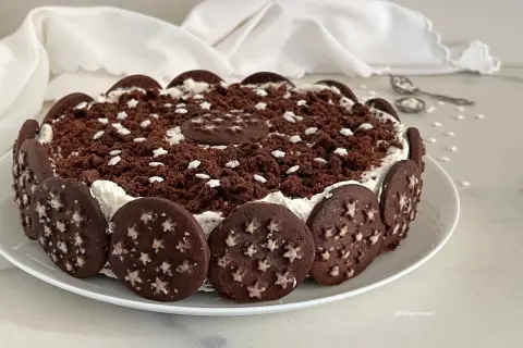 Torta Pan di Stelle decorata con biscotti al cacao e stelline bianche, un dolce che fa sognare.
