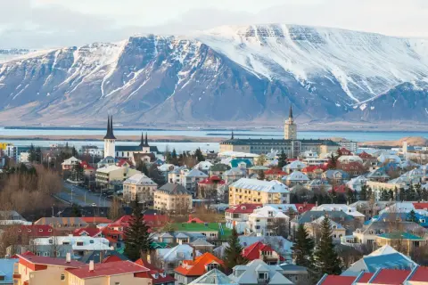 Reykjavik, stolica najbezpieczniejszego kraju w Europie, z kolorowymi dachami i ośnieżonymi górami w tle.