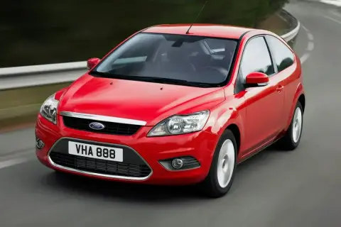 Czerwony Ford Focus MK2 1.6 TDCI w wersji 3-drzwiowej, jadący po zakręcie drogi.