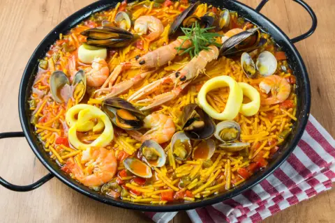 Fideuà catalane, un plat de pâtes aux fruits de mer, crevettes, moules, calamars et langoustines, prêt à être dégusté.