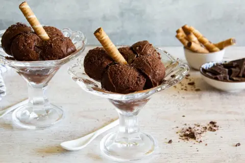 Coppette di granita al cioccolato, guarnite con cialde e scaglie di cioccolato.