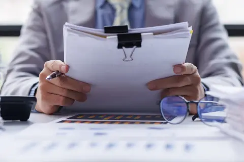 Biznesmen analizuje dokumenty, zastanawiając się nad strategią b2b. Co to znaczy? To relacje między firmami.
