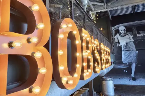 Lettre enseigne lumineuse "BOBSTER" sur fond d'une fresque vintage.