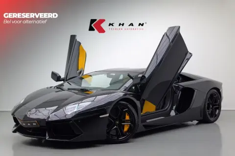 Czarny Lamborghini Aventador z otwartymi drzwiami, żółte akcenty we wnętrzu.