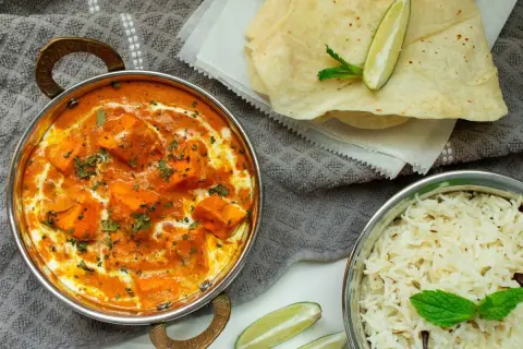 Un cremoso plato de paneer tikka masala, que es el curry, acompañado de arroz basmati y pan naan.