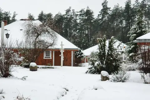 Śnieżne Boże Narodzenie na Kaszubach. Drewniane domki agroturystyki otoczone lasem i pokryte białym puchem.
