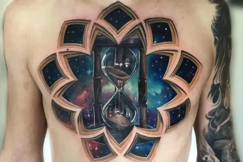 Un impresionante tatuaje 3D en el pecho de un reloj de arena cósmico, con capas que revelan un universo estrellado.