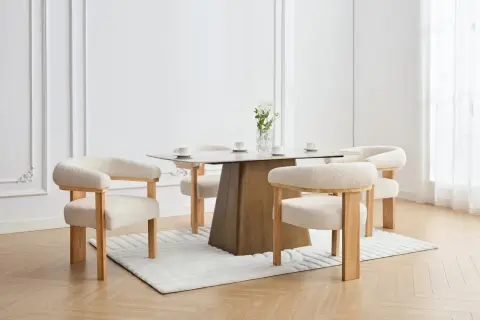 En elegant matplats med olika stolar runt ett modernt matbord. En vas med blommor står på bordet.
