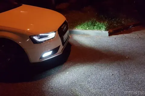 Białe Audi A4 B8 po lifcie z zapalonymi światłami przeciwmgielnymi. Wymiana żarówki przeciwmgielnej zakończona sukcesem.