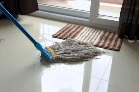 Mopa limpiando un suelo de gres para recuperar su brillo.