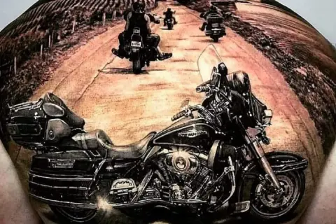 Niesamowite tatuaże motocyklowe: motocykl i grupa motocyklistów na drodze.