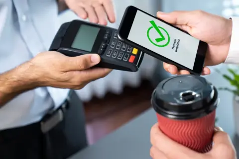 Szybkie zakupy kawy. Dowiedz się, jak płacić telefonem zbliżeniowo. Potwierdzenie płatności na ekranie smartfona.