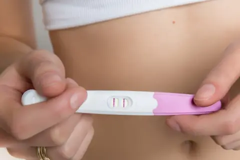 Dwie kreski na teście ciążowym, potwierdzające 4 tydzień ciąży. Objawy mogą być subtelne, ale ten test mówi wszystko.
