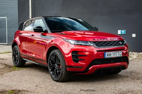 Czerwony Range Rover Evoque z czarnym dachem i felgami. Wiele osób szuka o nim pozytywnych **range rover evoque opinie**.