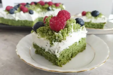 Zielony ciasto leśny mech na dużą blachę, przełożone kremem z serkiem mascarpone i ozdobione malinami i borówkami.