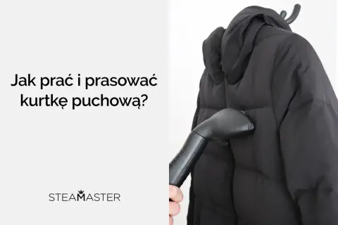 Parać i prasować kurtkę puchową parownicą Steamaster. Czarna kurtka na wieszaku, ręka trzymająca parownicę.