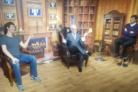 W muzeum figur woskowych w Łebie siedzą obok siebie trzy postacie.