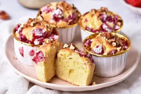 Puszyste muffinki z truskawkami, posypane orzechami, kuszą swoim wyglądem i zapachem. Idealne na deser.