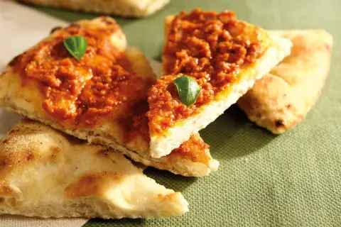 Tranches de pizza basilic, garnies d'une sauce rouge savoureuse et d'une feuille de basilic frais.