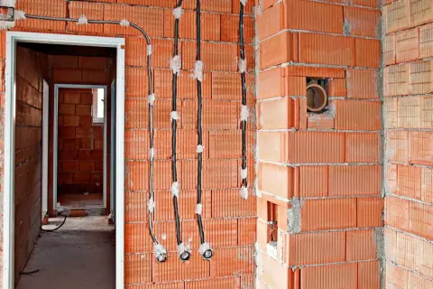 Nowe przewody elektryczne prowadzone po powierzchni ścian z pustaków ceramicznych, umożliwiające wymianę instalacji elektrycznej bez kucia.