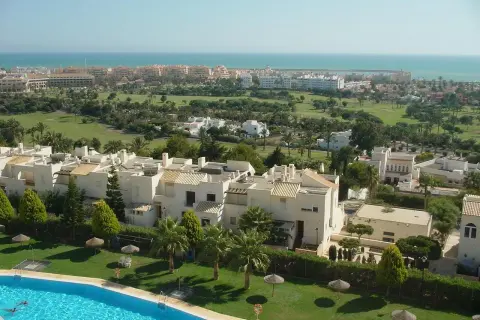 Vista aérea de Almerimar: complejos residenciales blancos, campo de golf verde y el mar azul. Ideal para saber qué ver en Almerimar.