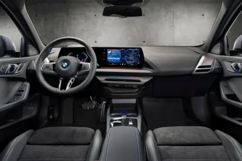 Interiör i en BMW med digital instrumentpanel, stor infotainmentskärm som visar navigation och en ratt med Steptronic-funktion.