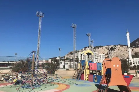 Parque infantil colorido con el Peñón de Gibraltar al fondo. ¡Un lugar ideal que hacer en Gibraltar con niños!