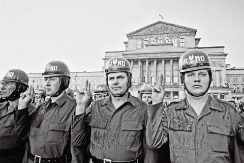 ZOMO, czyli co to za formacja? Milicjanci w hełmach z napisem ORMO, w mundurach, na tle monumentalnego budynku.