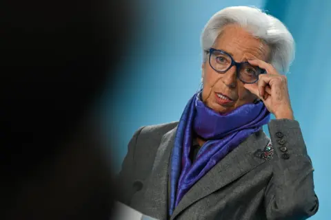 Eine Frau mit Brille und Schal, eine der EZB-Ratsmitglieder, richtet ihre Brille.
